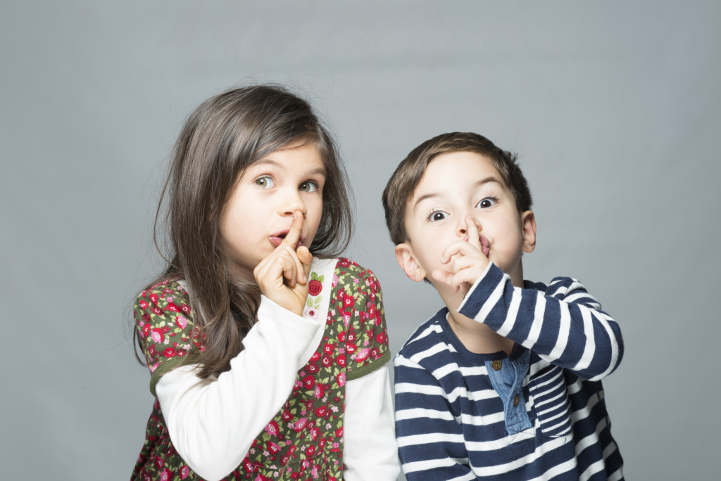 Girl and boy with hush gesture